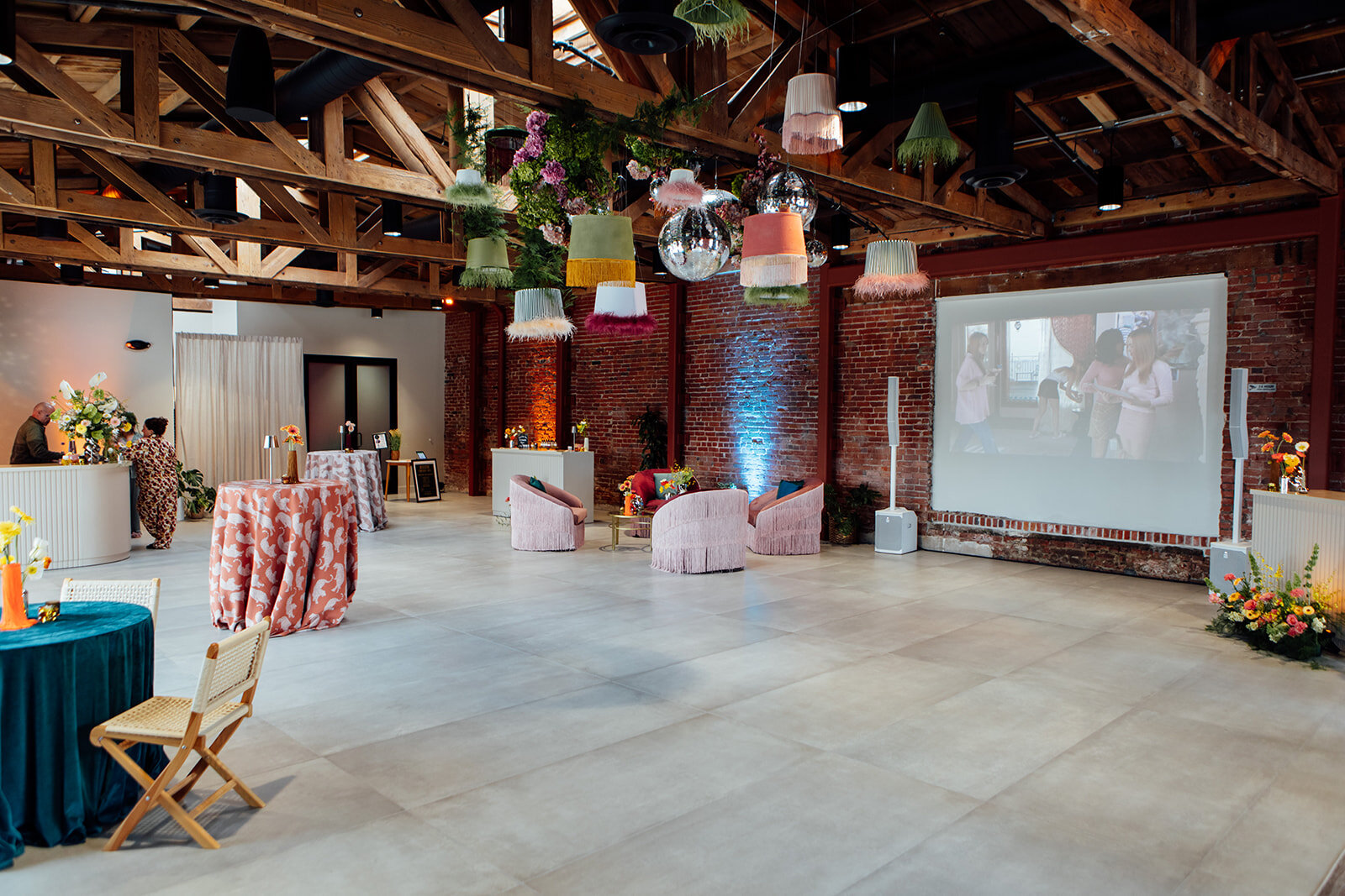 Colorful pendant decor, patterned cocktail tables, lounge seating and a projection screen inside Palomino.