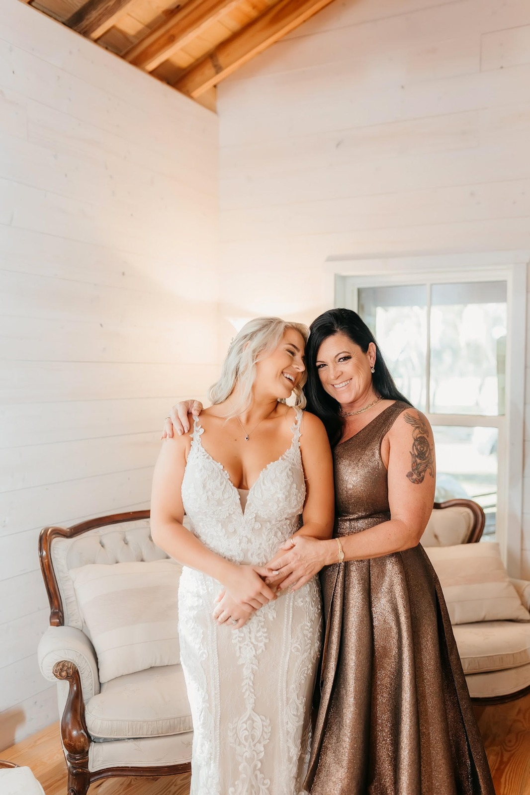 Bride and her mom laughing together before the ceremony