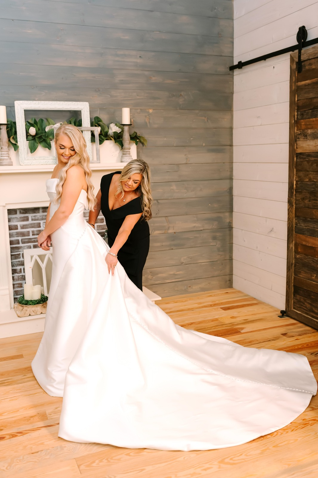 Mom fluffing the bride’s train in the bridal suite
