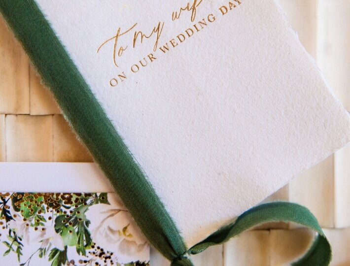 Green velvet wedding vow book with a handwritten note