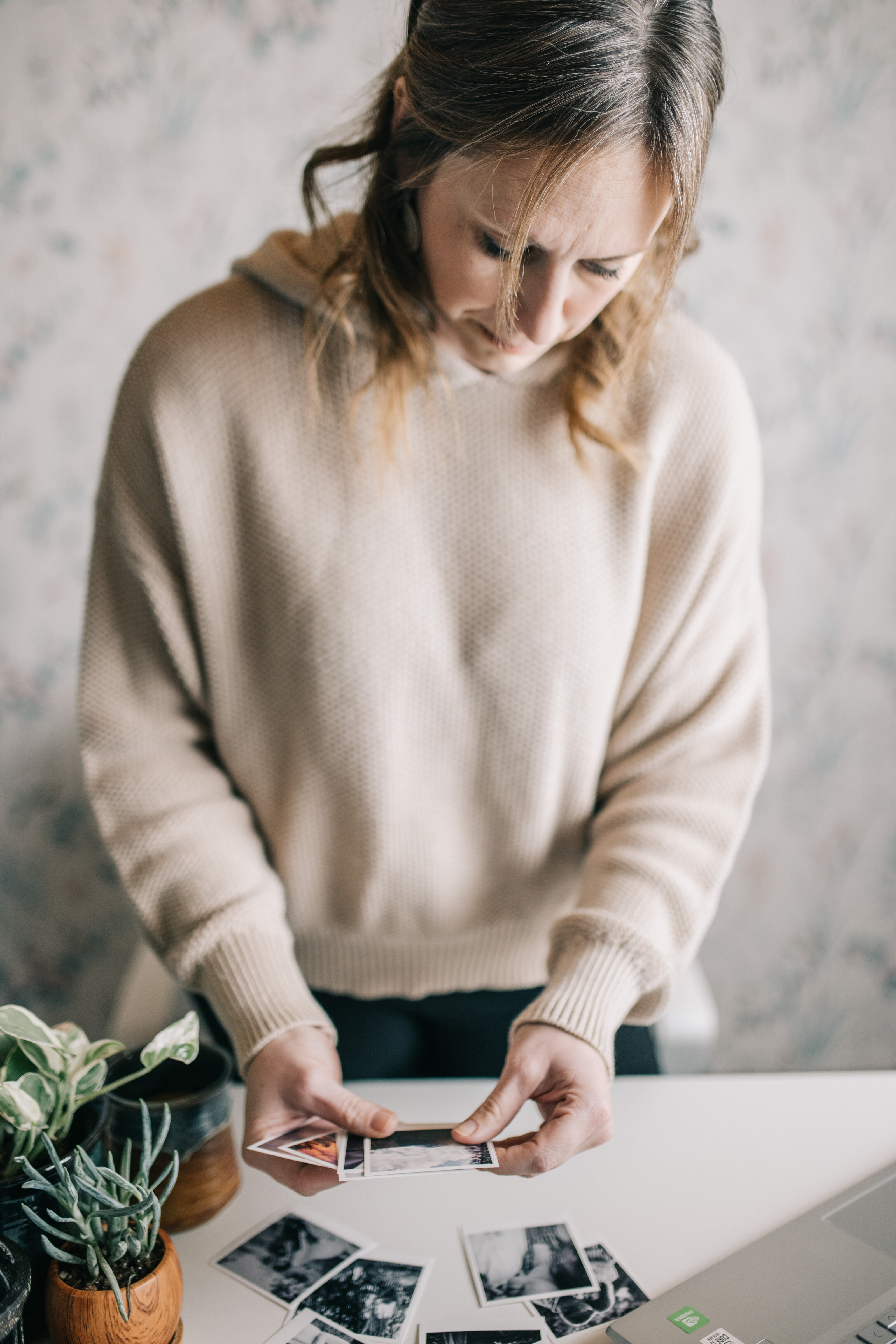 Emily McNiel reviewing printed photographs at her desk