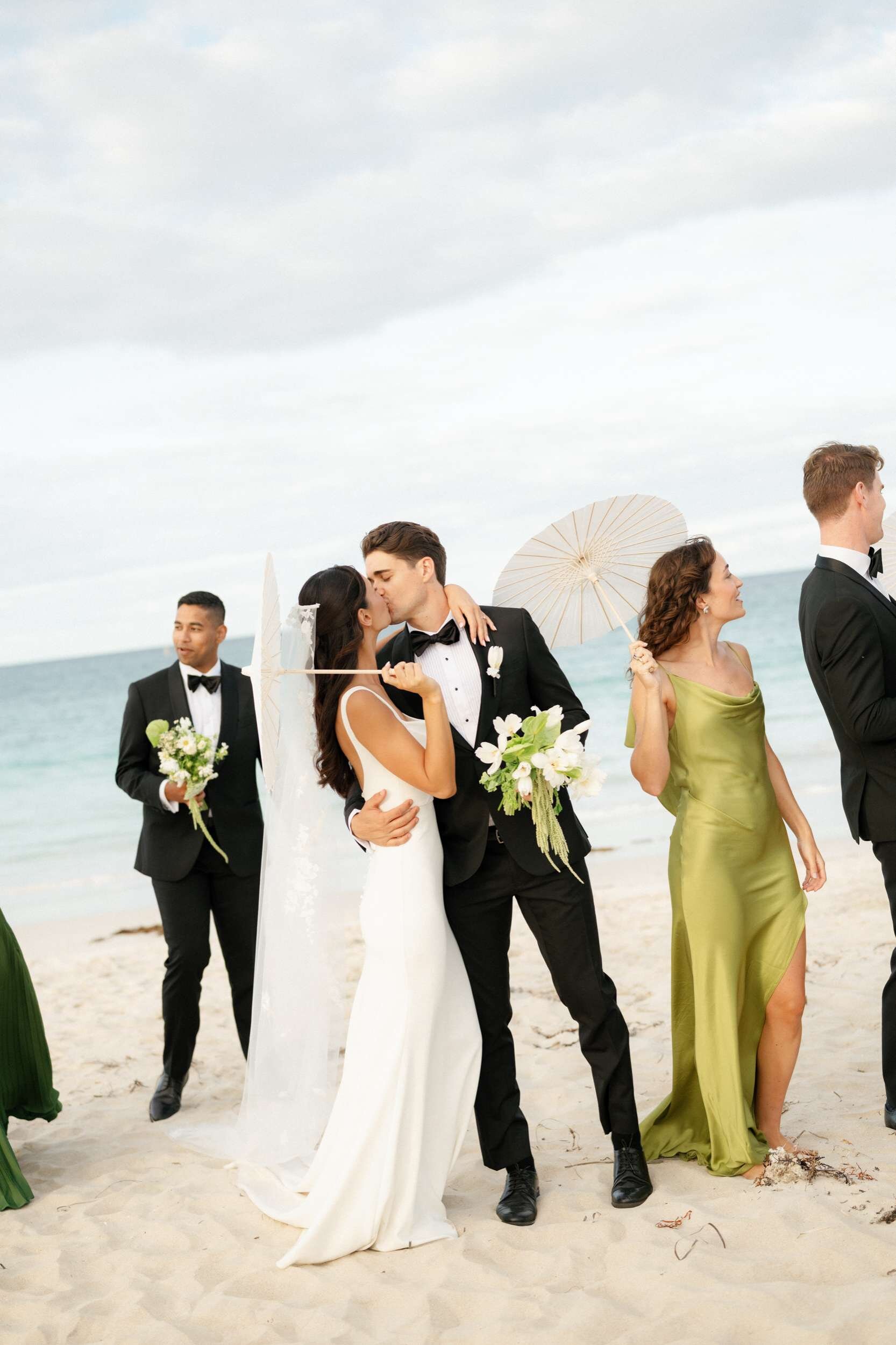 Real Perth wedding, Lisa and Luke kiss with bridal party parasols