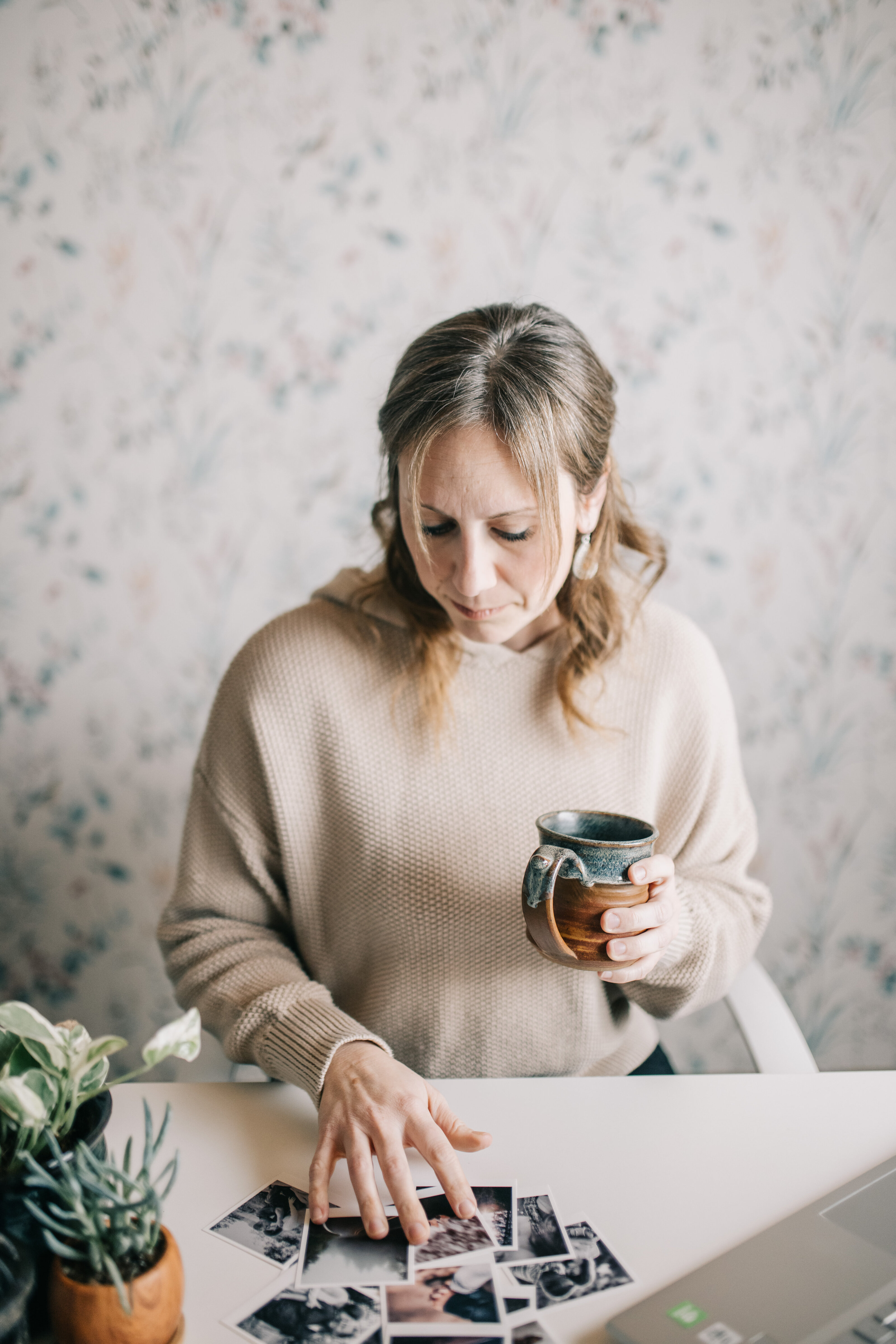 Emily McNiel at her desk with coffee and photographs