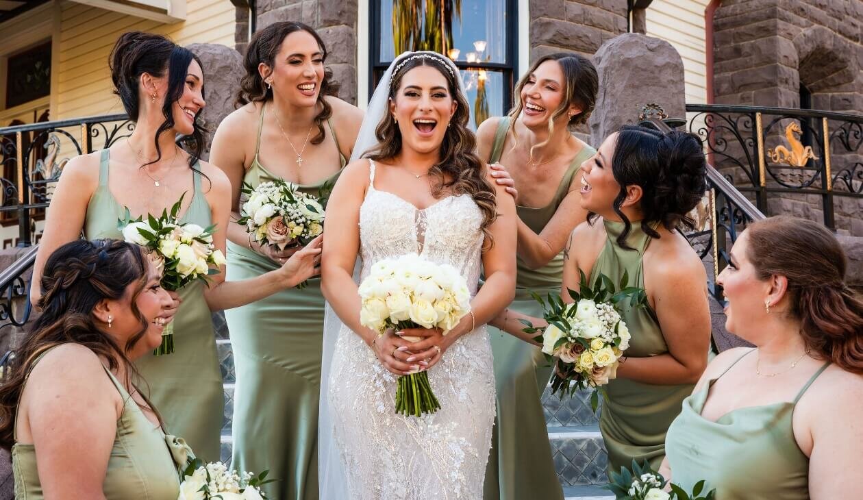 Bride laughing with bridesmaids in sage green dresses