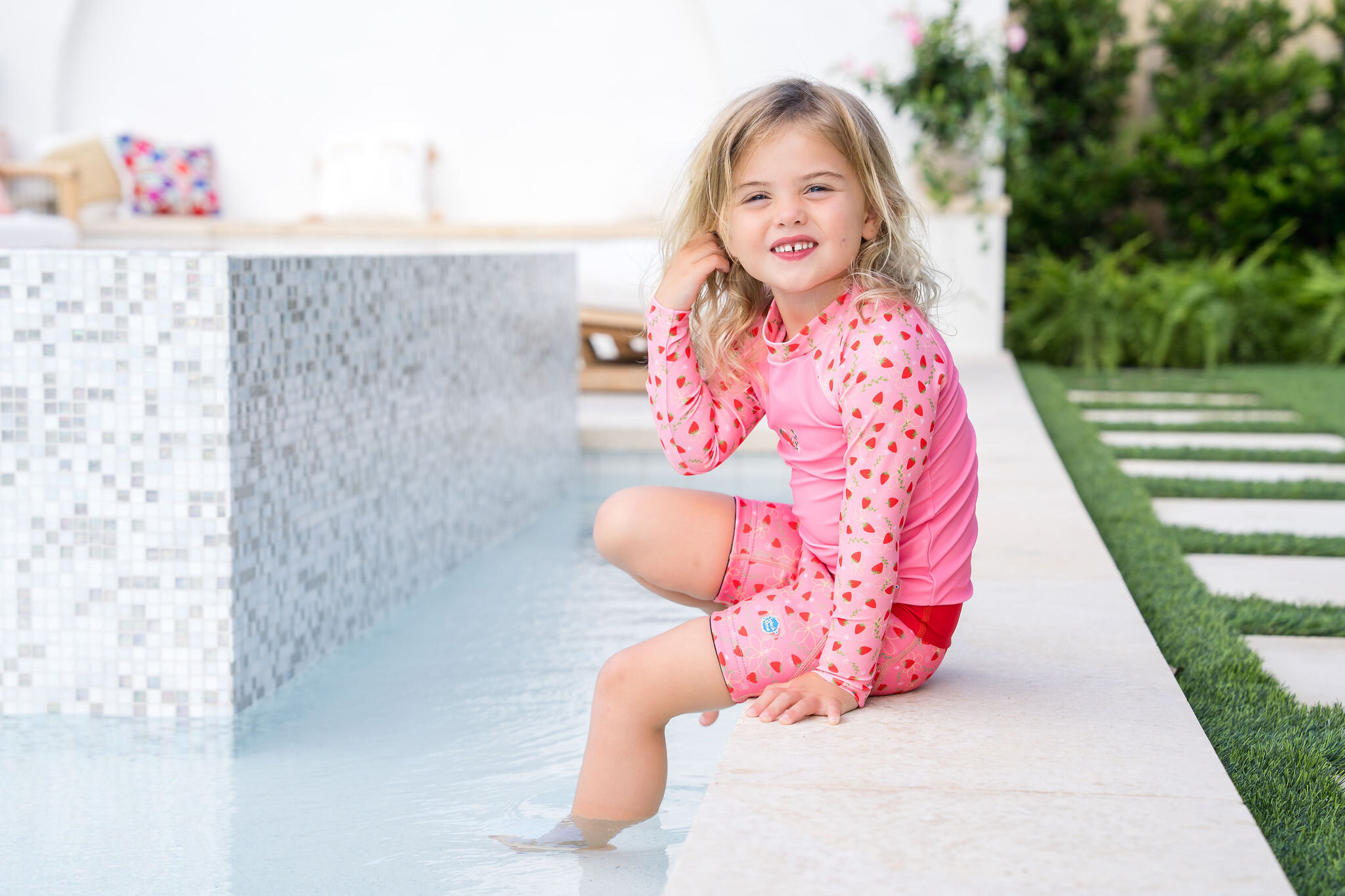 Portrait of a girl in a strawberry print rash guard for Splash About swimwear