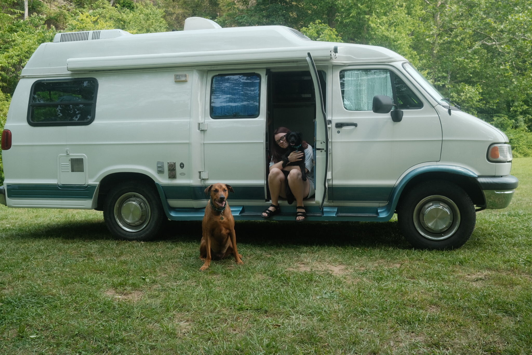Mason Jesmer's wife and their two dogs with the camper van they live in full time