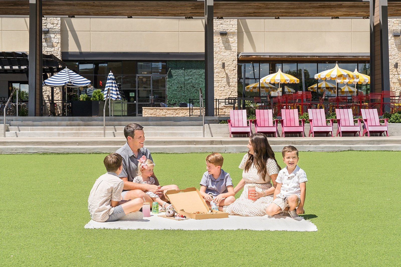Family picnicking on the lawn at Hill Country Galleria, Austin