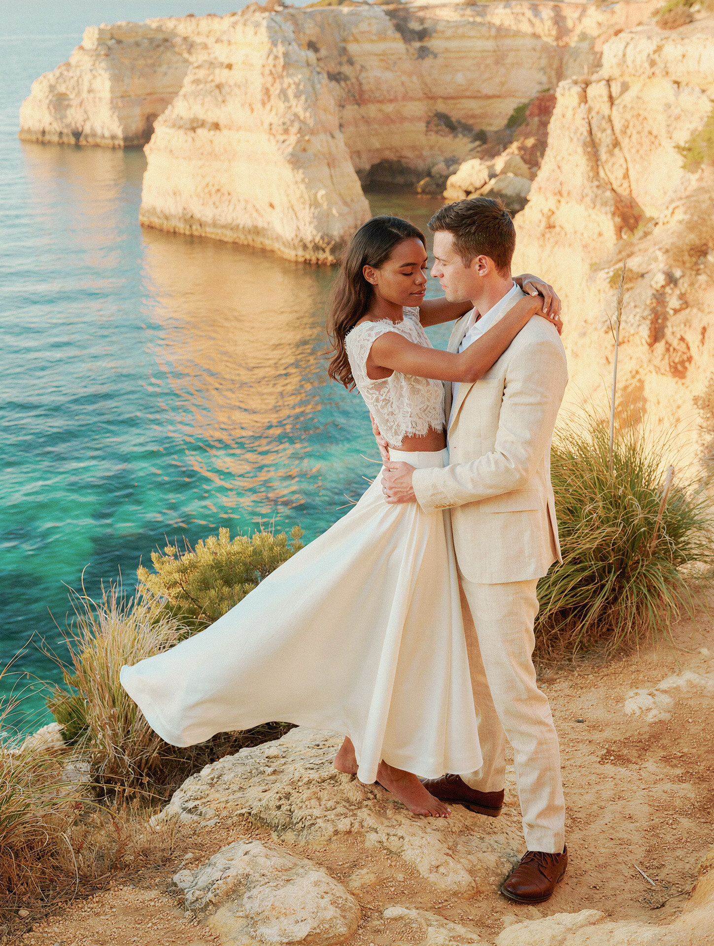 Portugal sea-cliff destination wedding photography of a bride and groom embracing