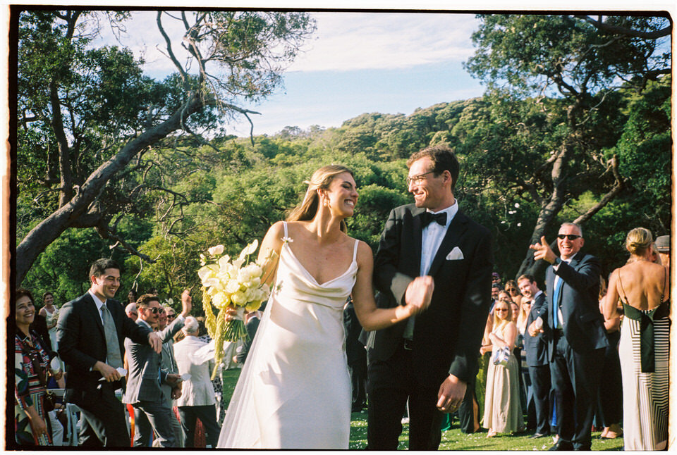 Newlyweds walking down the aisle at a Yallingup wedding ceremony, captured on genuine 35mm film