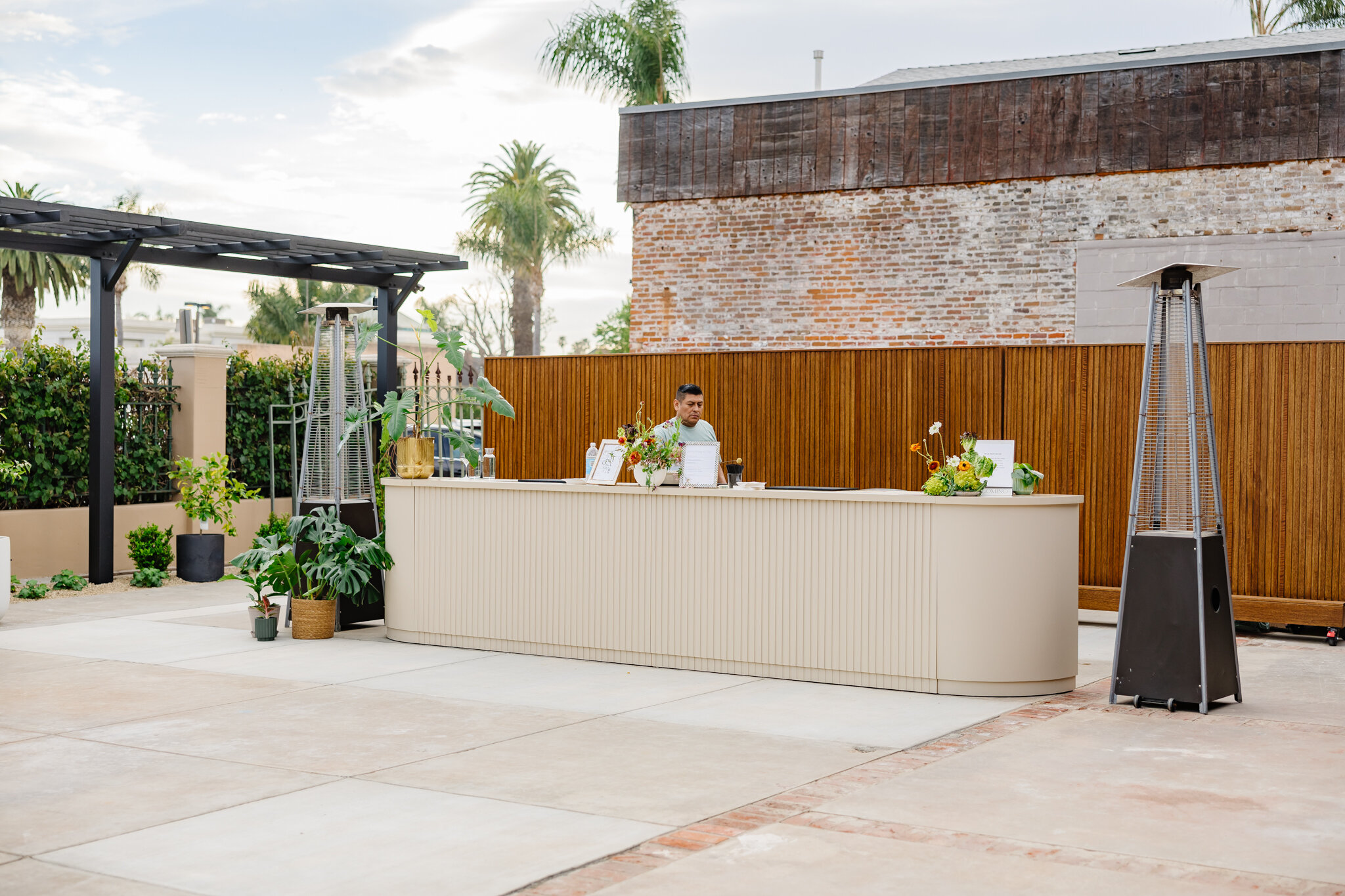 Palomino’s long modular bar positioned outdoors with floral arrangements and patio heaters.