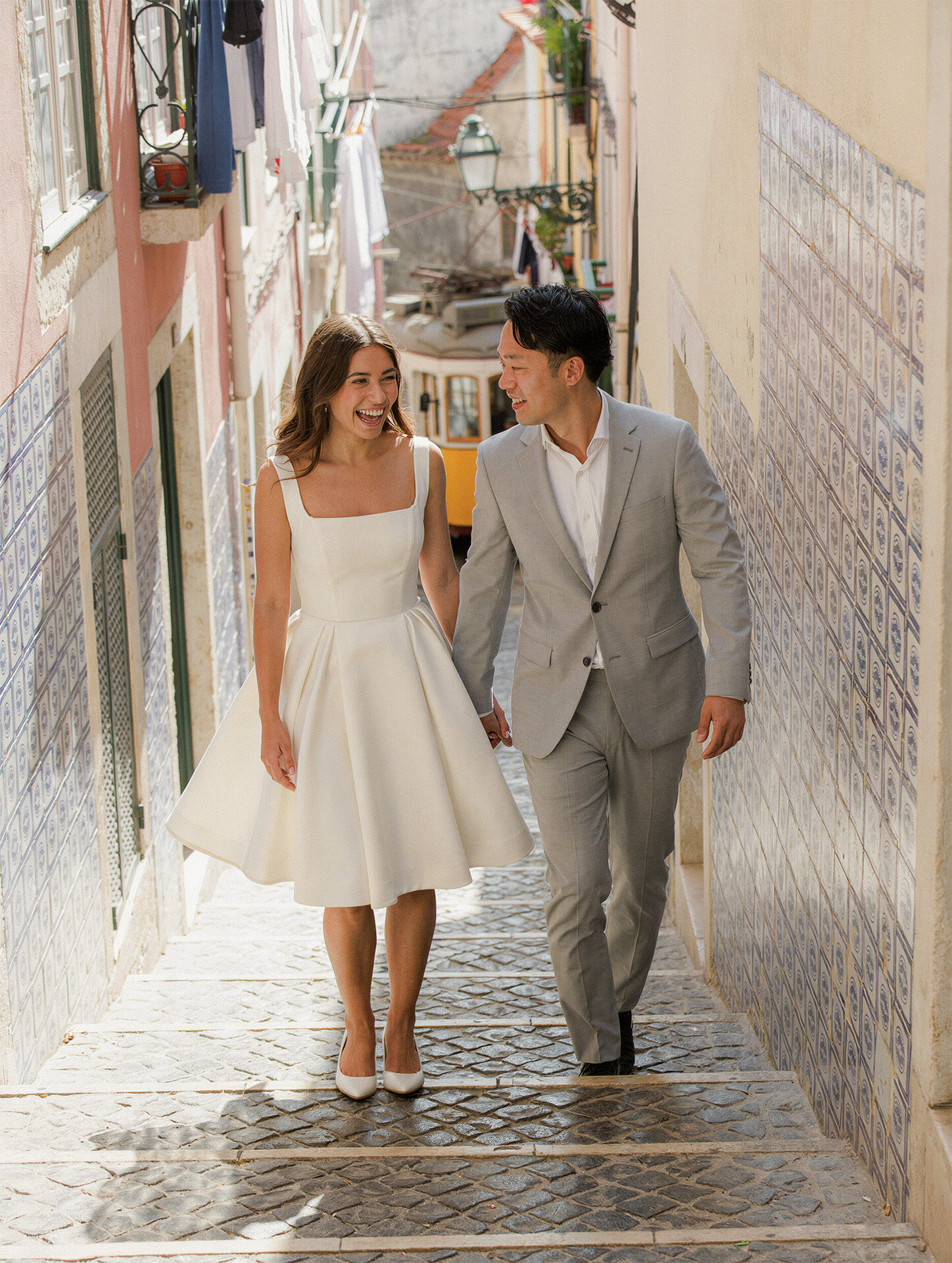 Lisbon destination wedding photography of a bride and groom walking through a historic alley