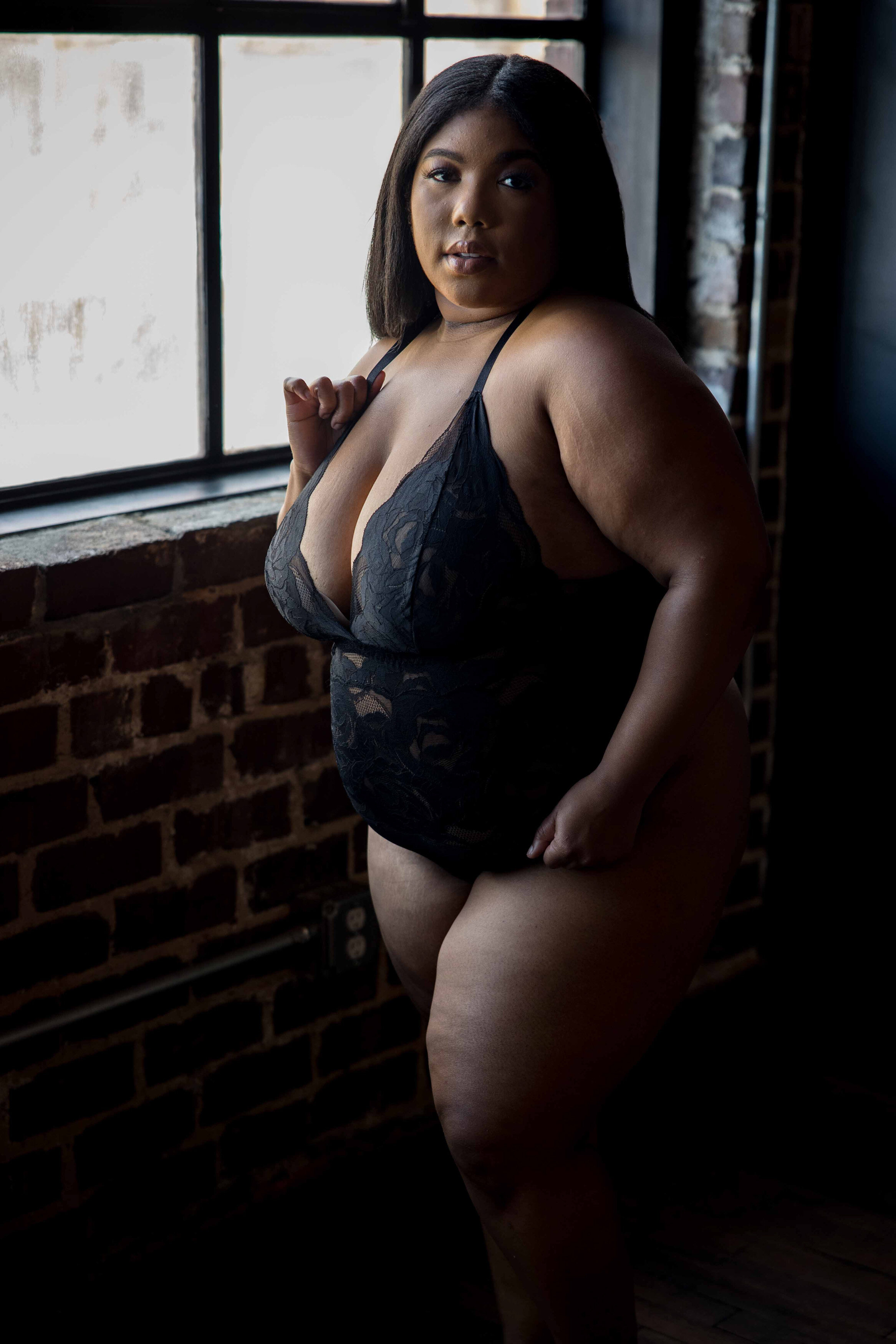 Plus size woman posing in a bodysuit during a DC boudoir photo session with Nicole Griffin Photography