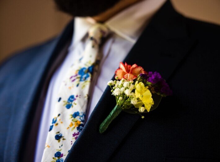 Groom’s floral tie and colorful boutonniere detail