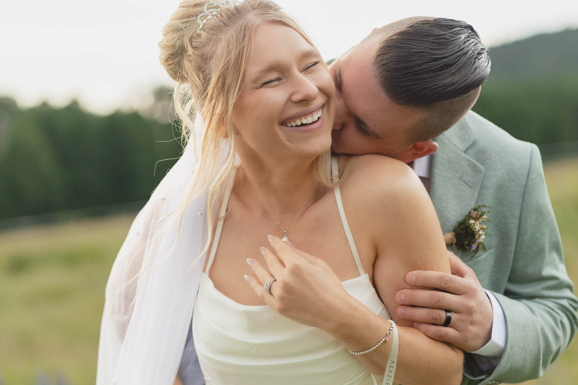 Fall wedding in Flagstaff with groom embracing the bride from behind and kissing her neck