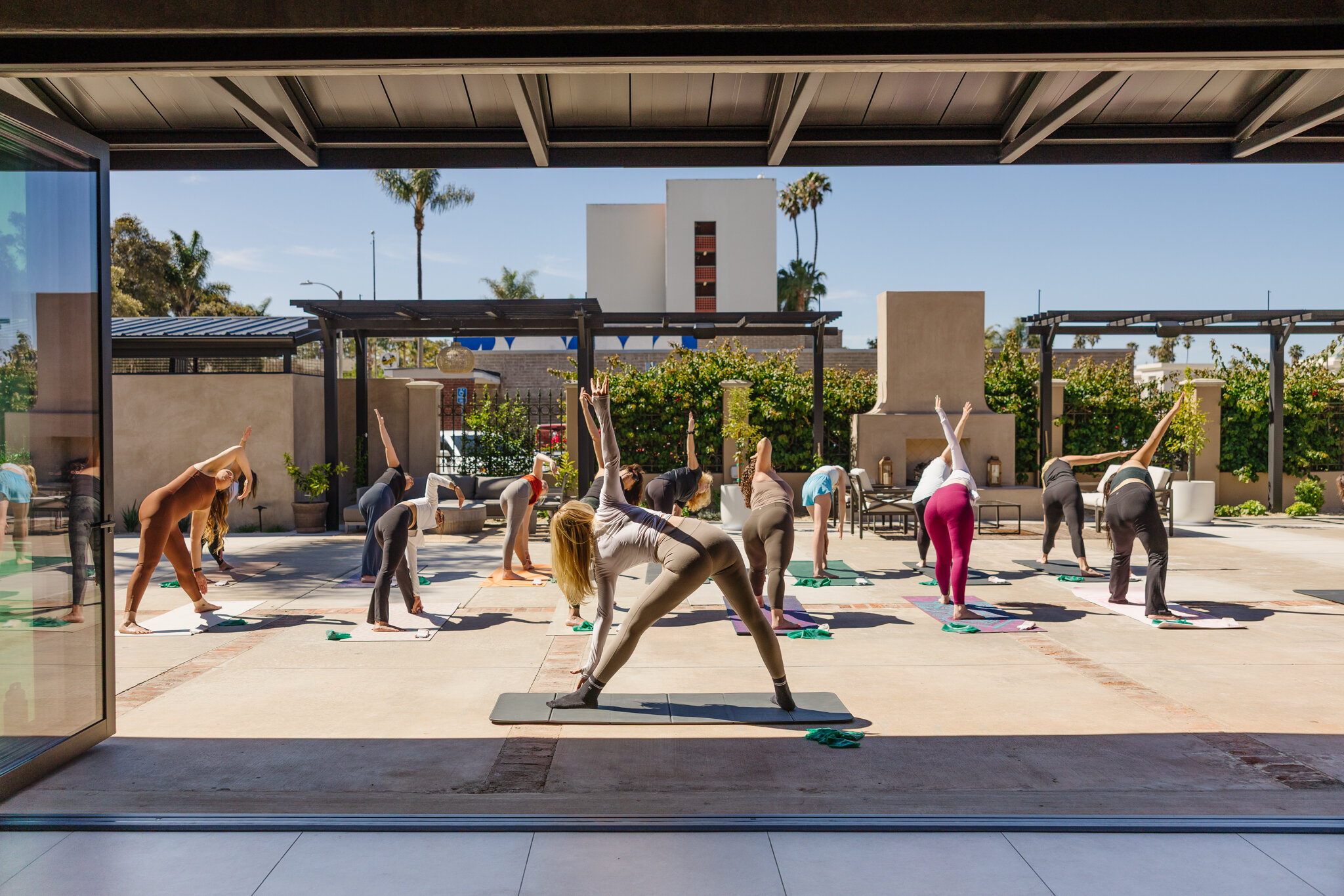 Yoga participants on the patio viewed through Palomino’s fully opened indoor-outdoor doors.