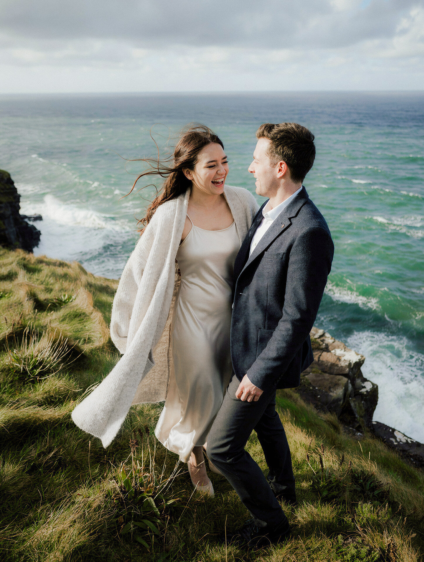 Bride and groom portrait beside dramatic Irish sea cliffs photographed in true-to-life color