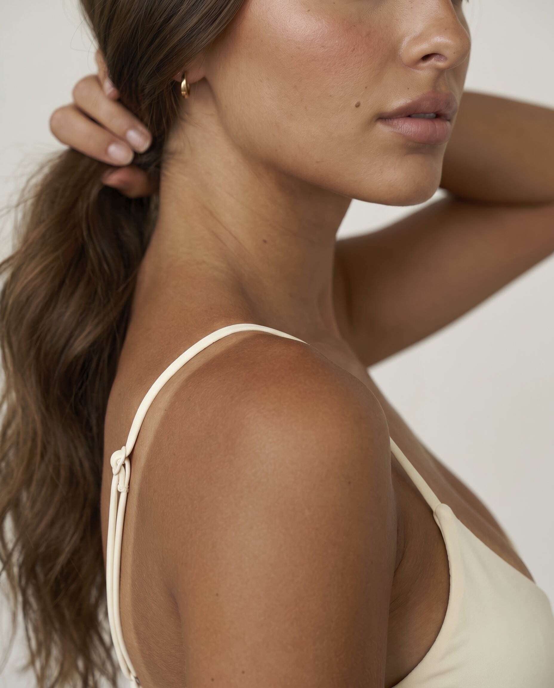 Warm bronzed skin and a cream top