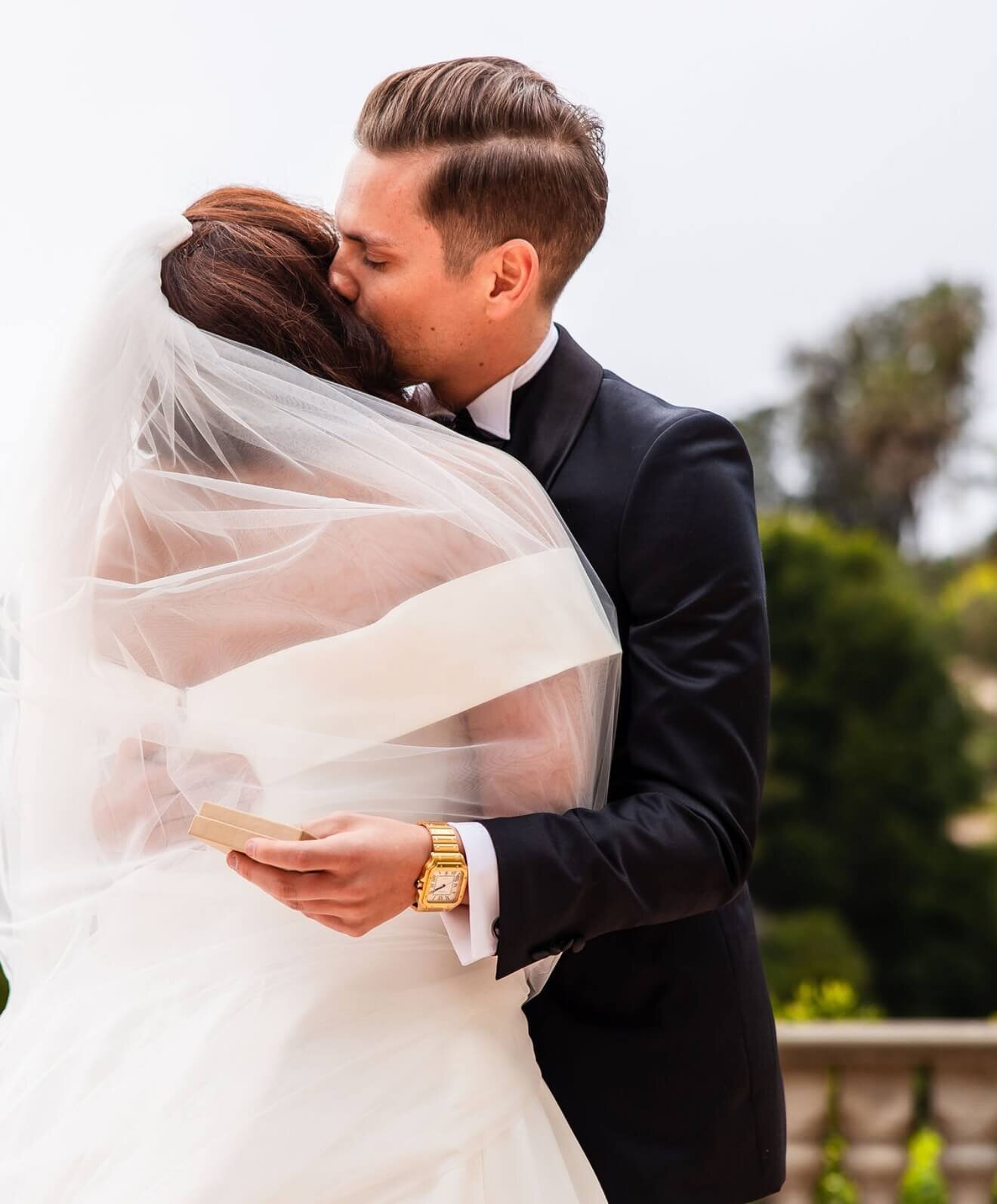Bride and groom embracing beneath her veil at a Southern California wedding