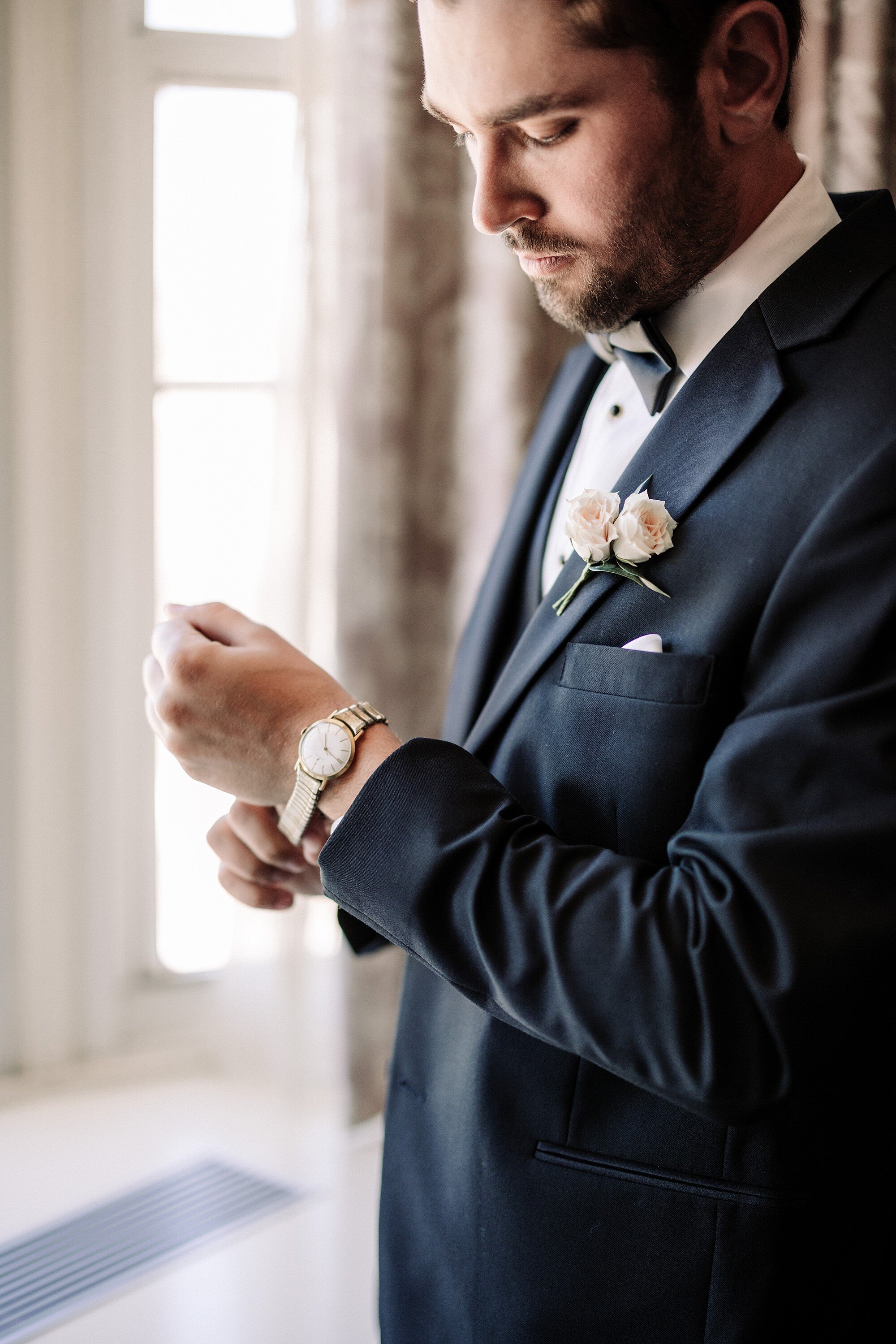 Groom fastening his cuff before the ceremony
