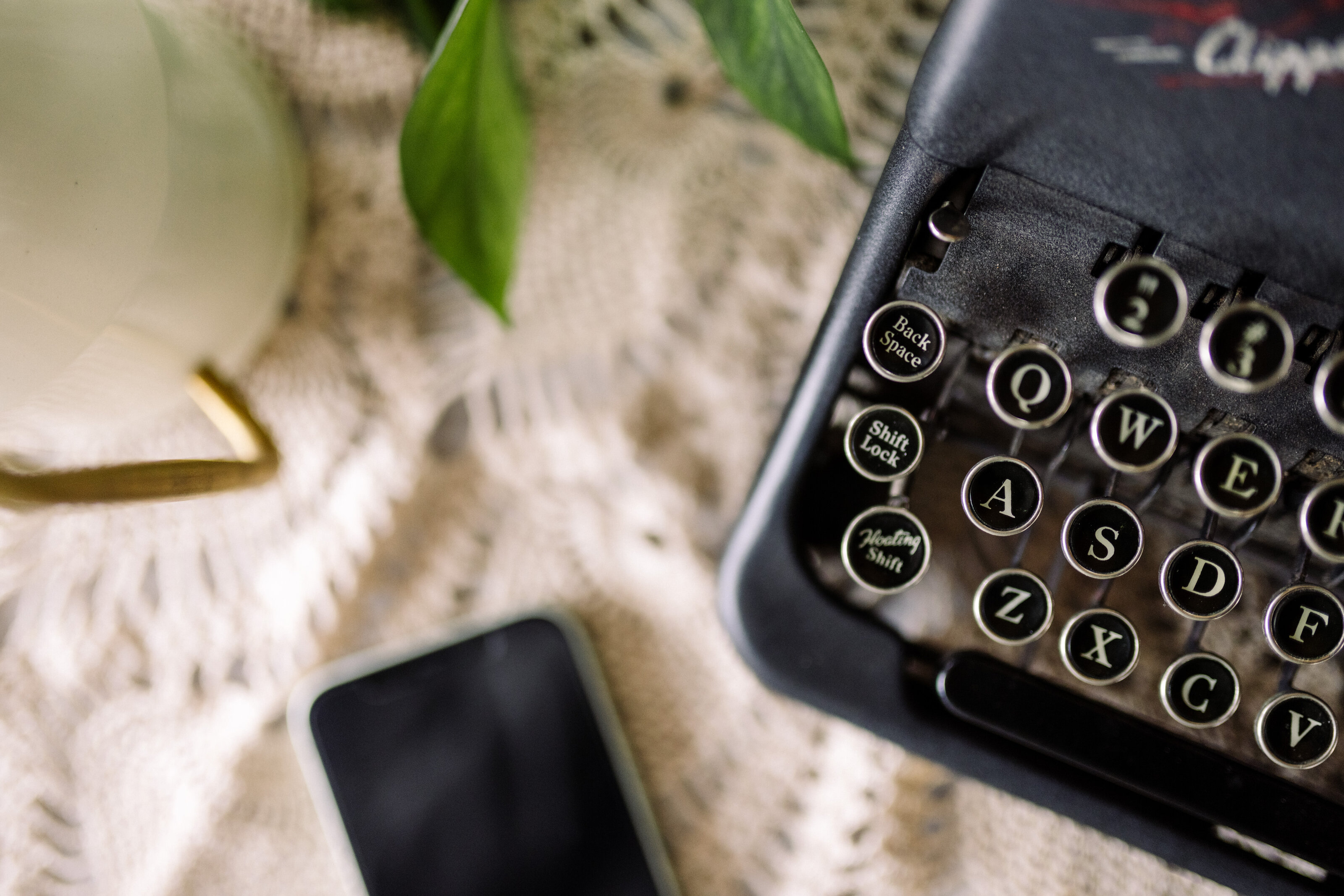 Vintage typewriter and phone on a soft blanket