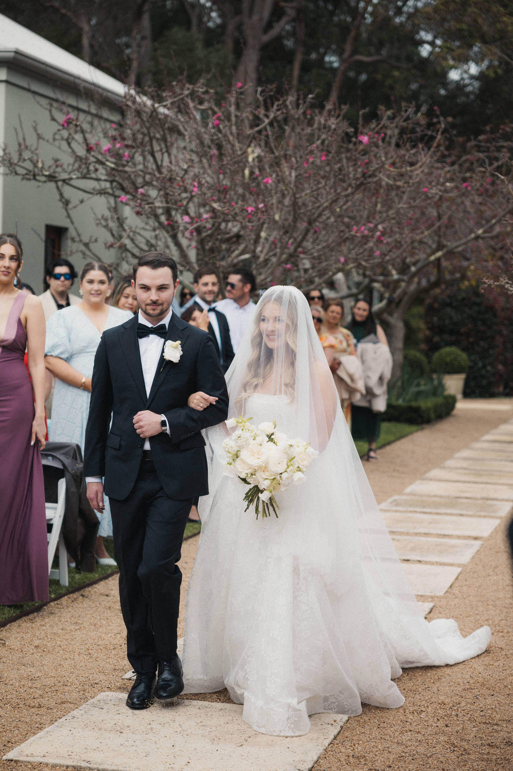 Bride walking down the aisle with her brother at Margaret River's Secret Garden