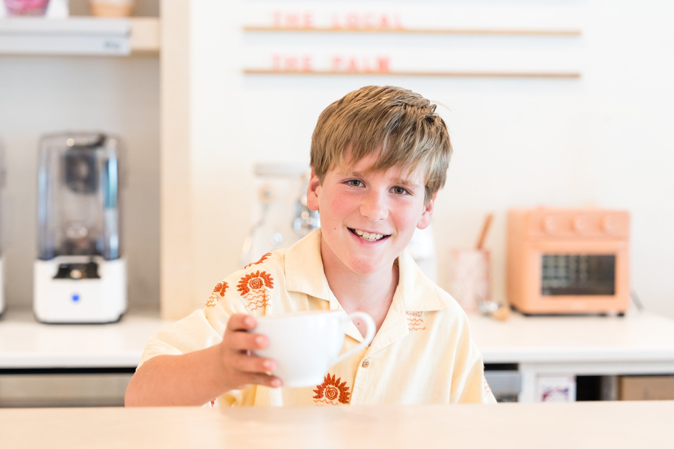 Child at the counter with a coffee mug at Real + Raw 30A