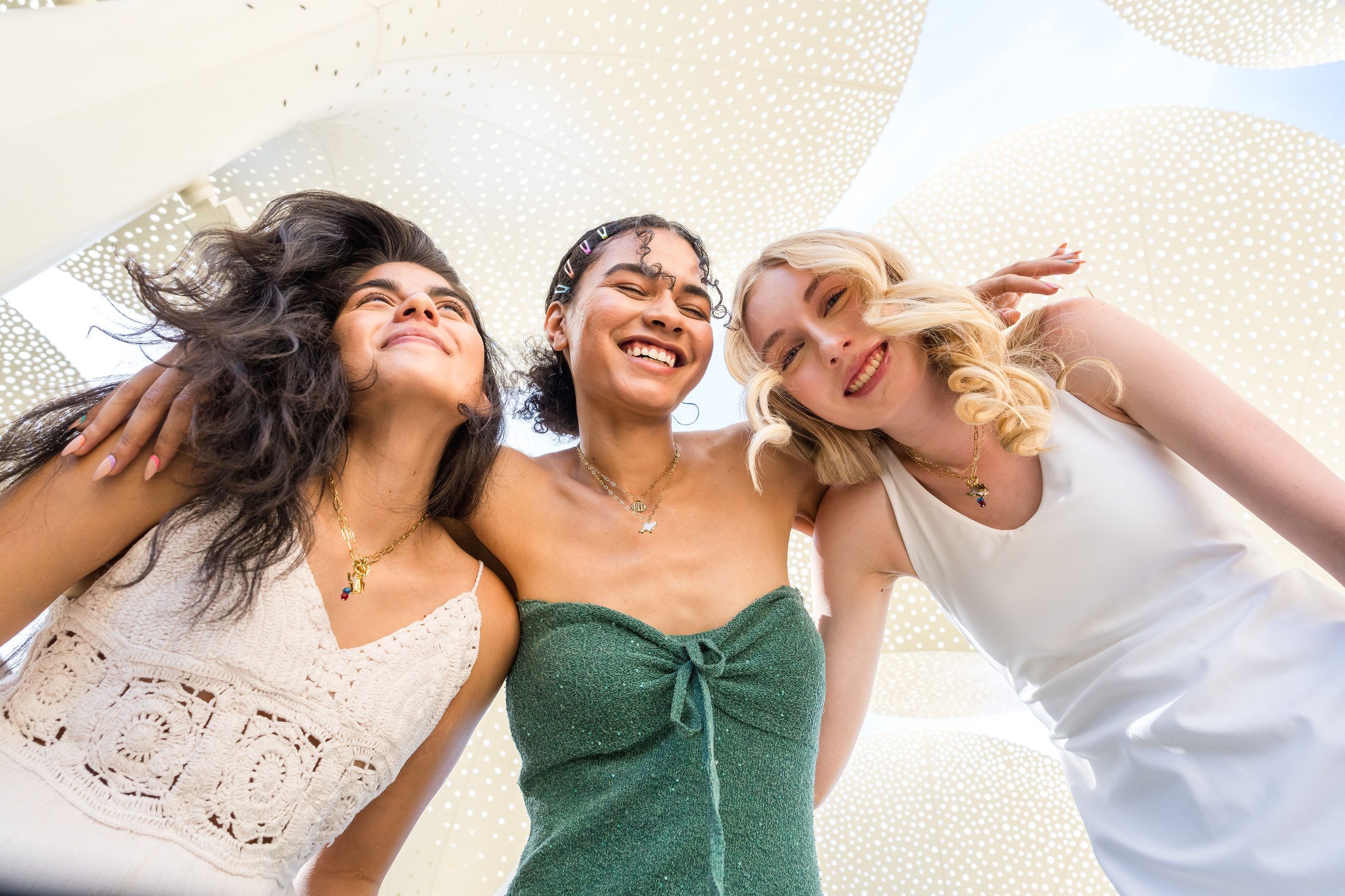 Three Charm Theory models laughing together against a stone wall in Austin