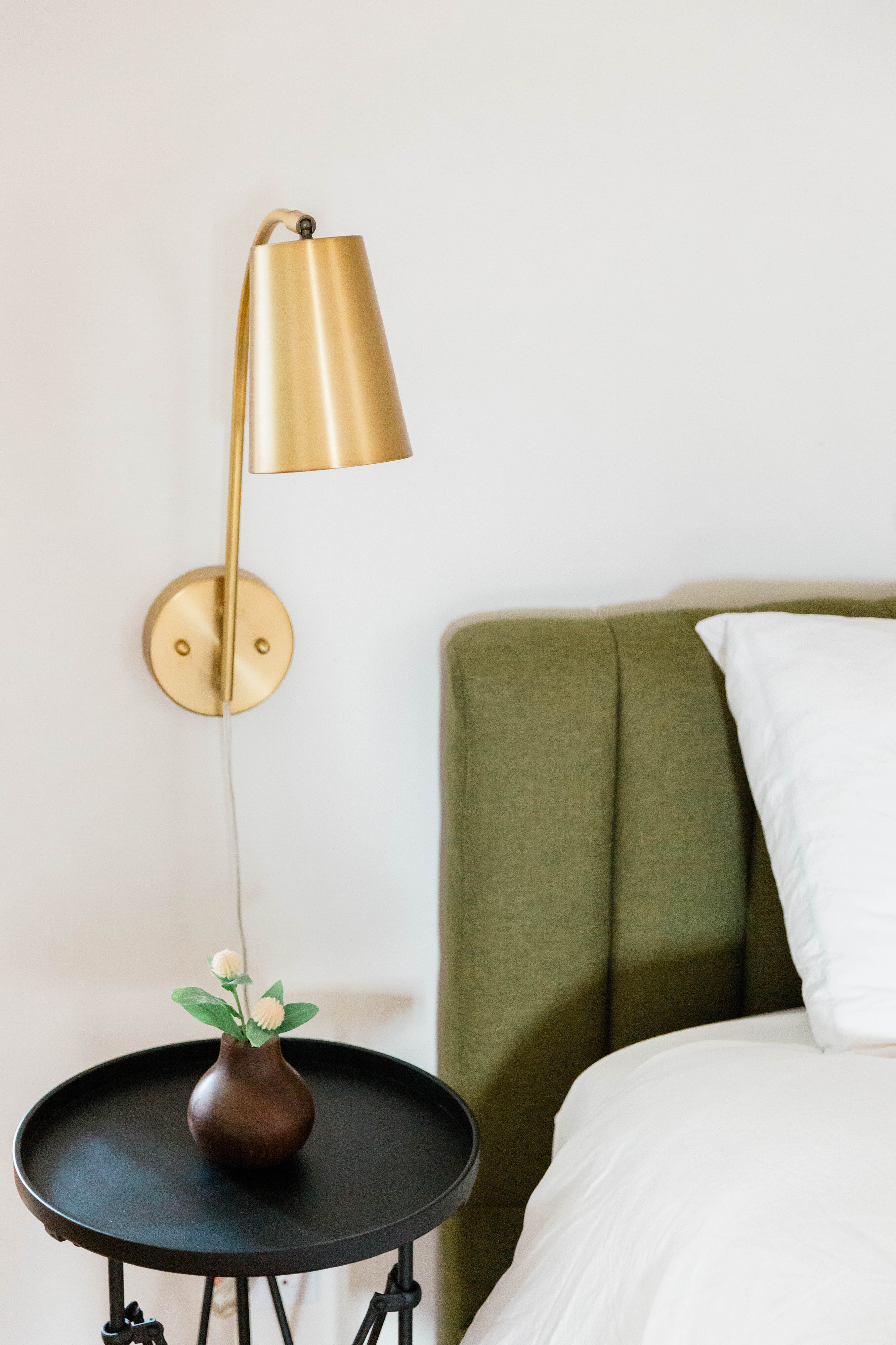 Interior vignette with green chair and gold sconce