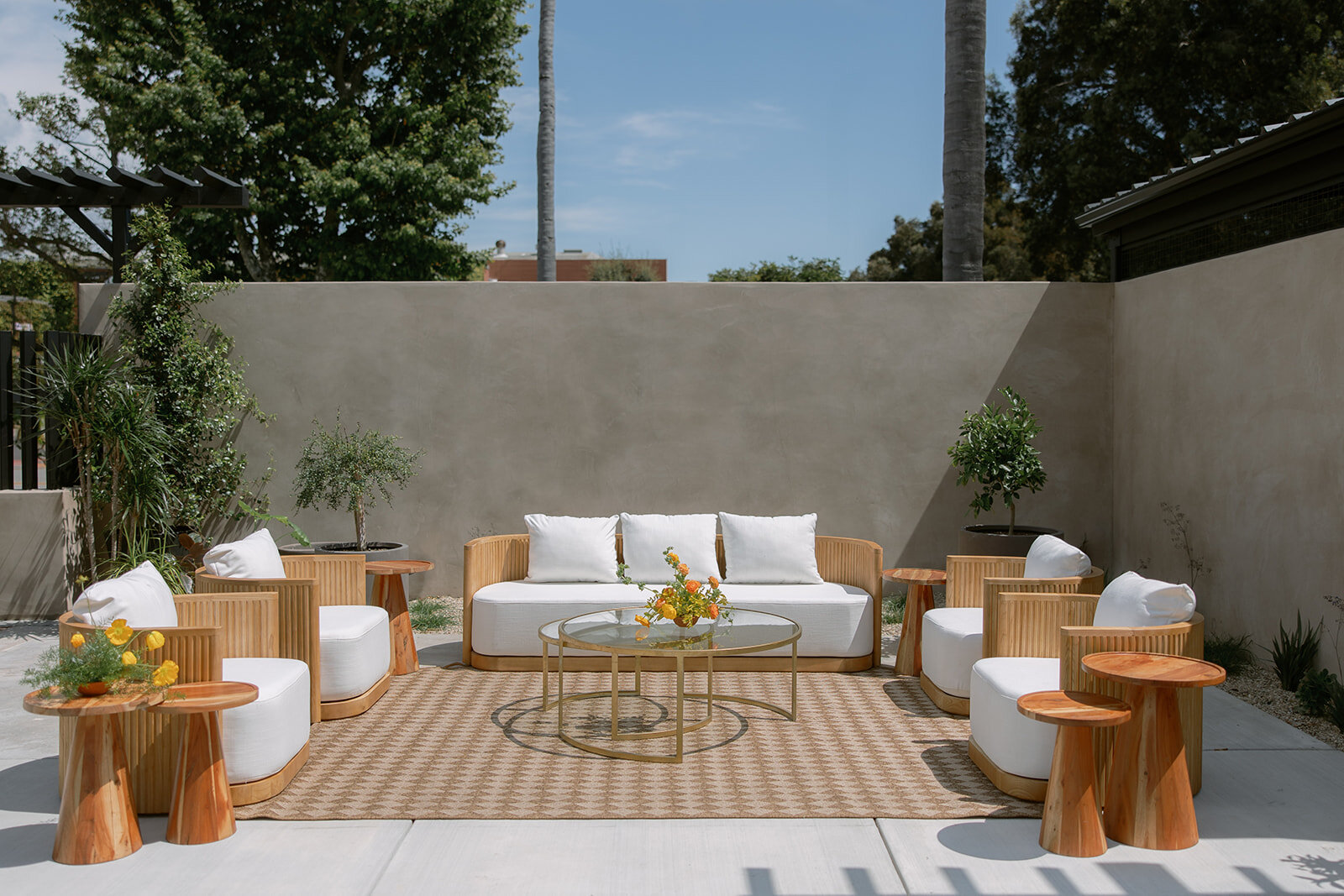 Neutral cushioned sofas, curved chairs and wood tables arranged as a conversational lounge on Palomino’s patio.