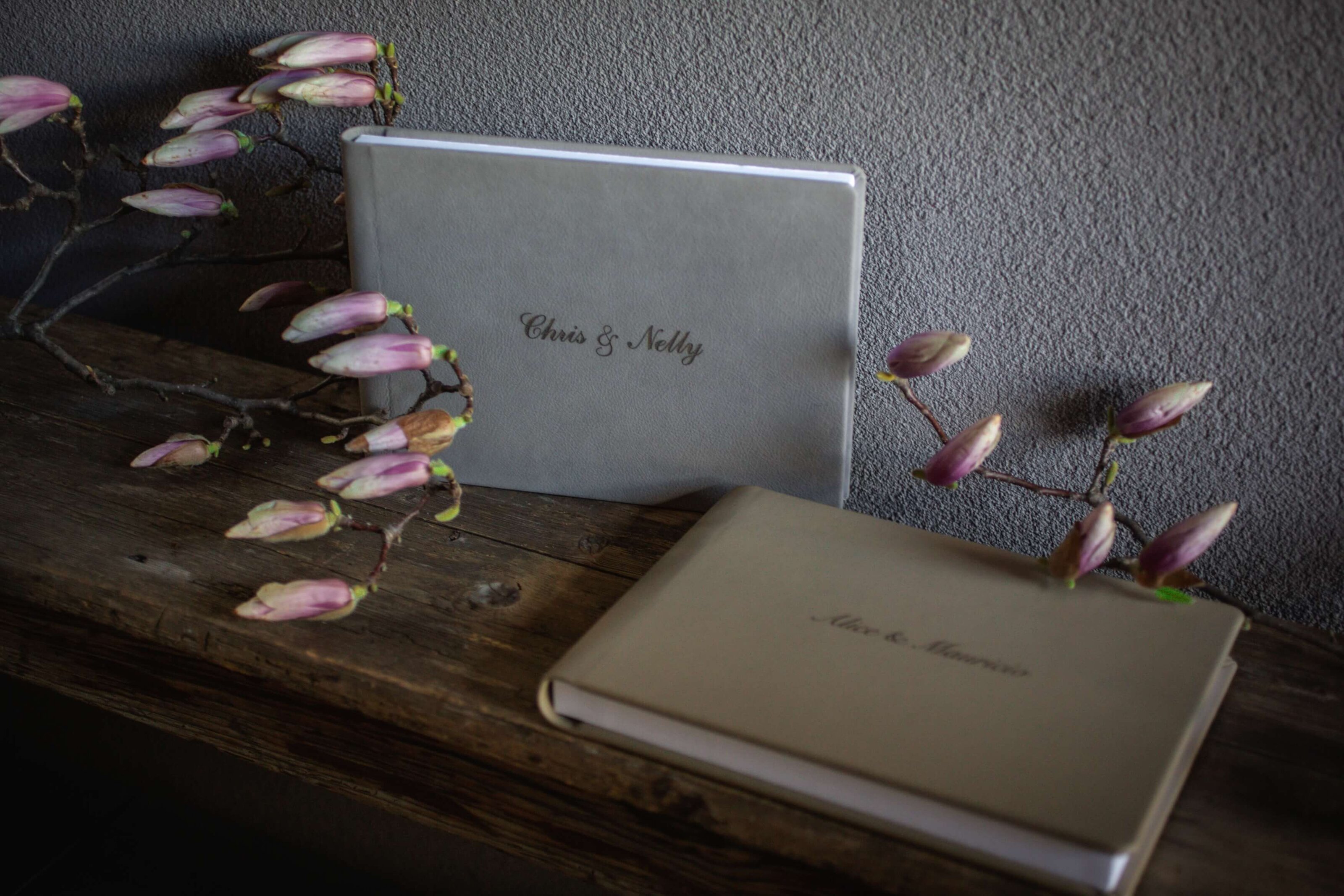Personalized wedding guest books displayed with pink flowers