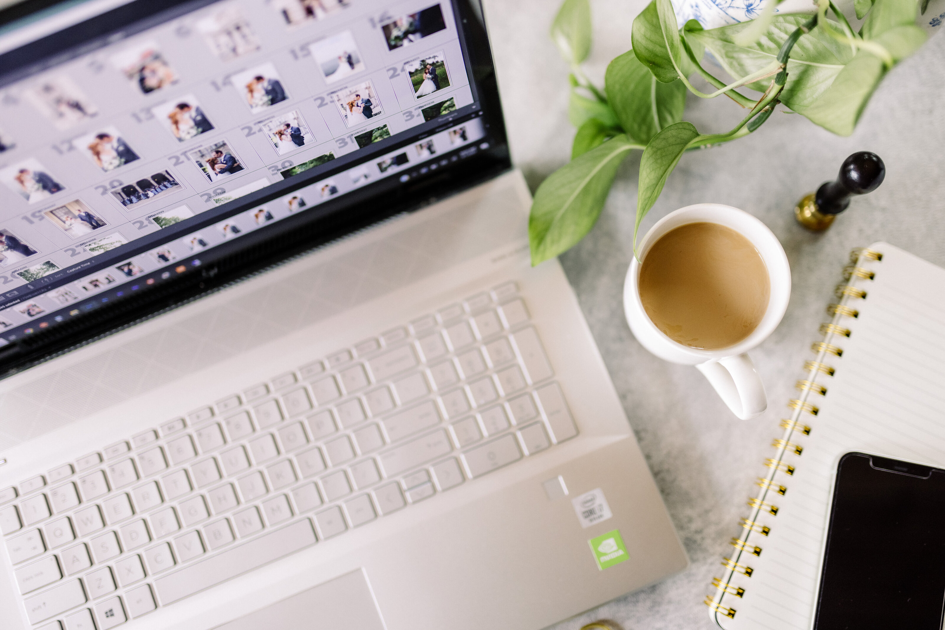 Laptop with a wedding gallery open beside a cup of coffee