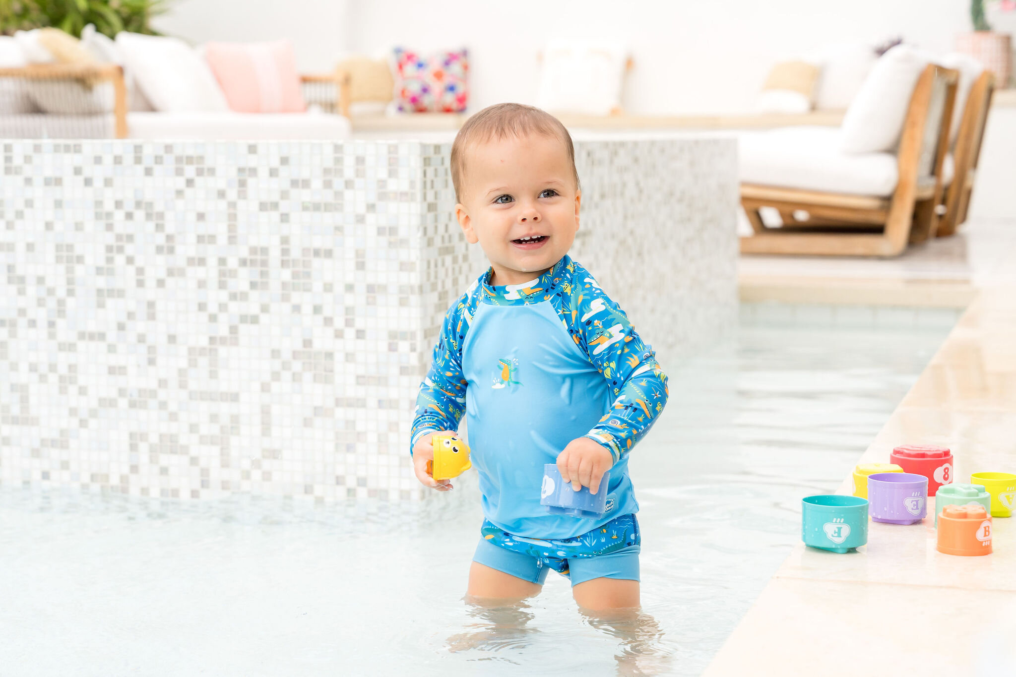 Child wearing a crocodile print rash guard poolside for Splash About