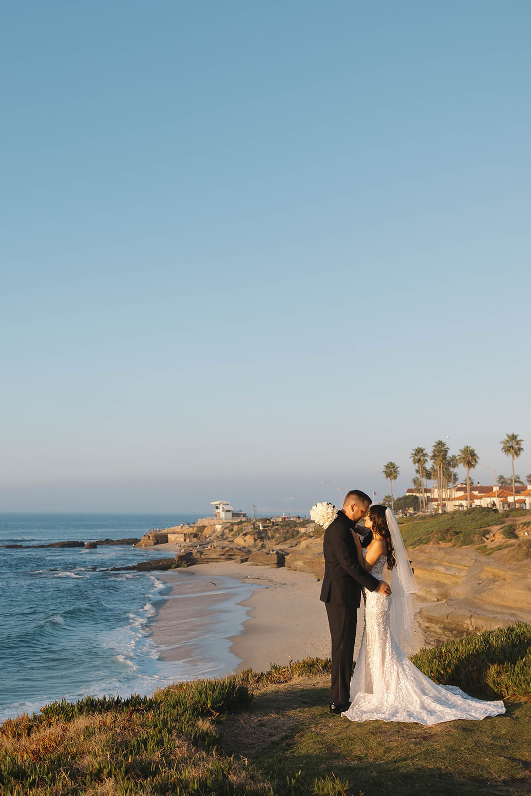 Bride and groom on the bluffs above the ocean
