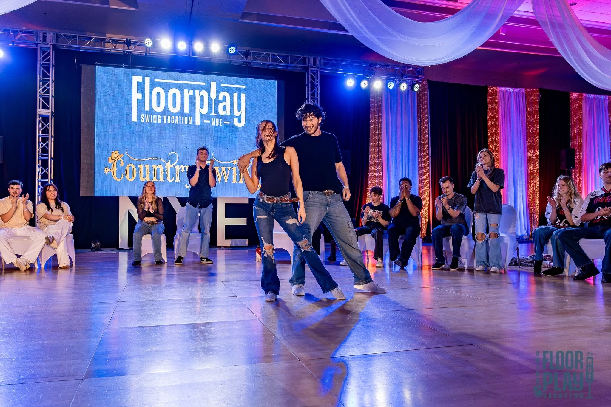 Country Swing partners on the Floorplay dance floor with an audience nearby