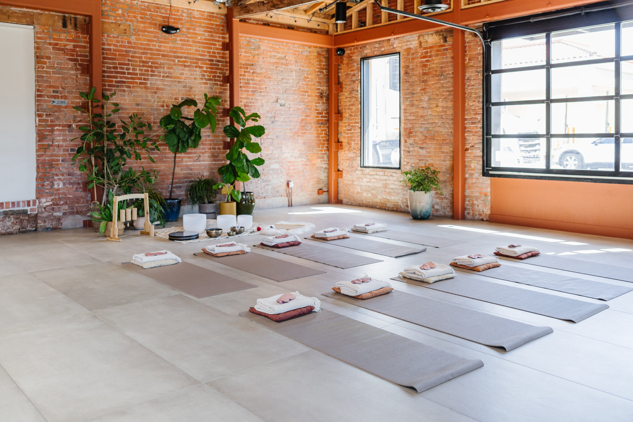 Yoga mats, folded blankets and cushions arranged for a wellness gathering inside Palomino.