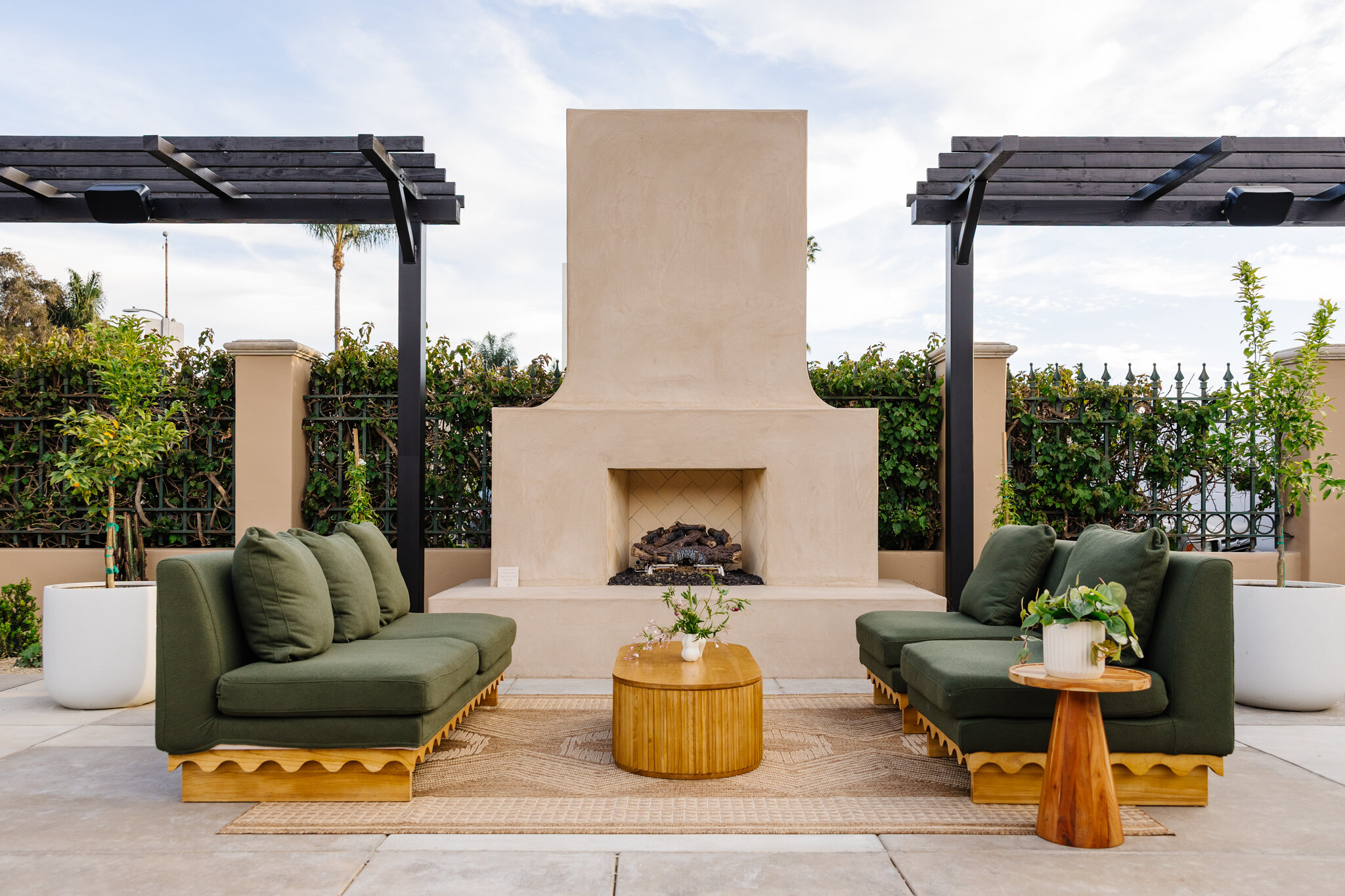 Green lounge seating and wood tables arranged symmetrically around Palomino’s outdoor fireplace.