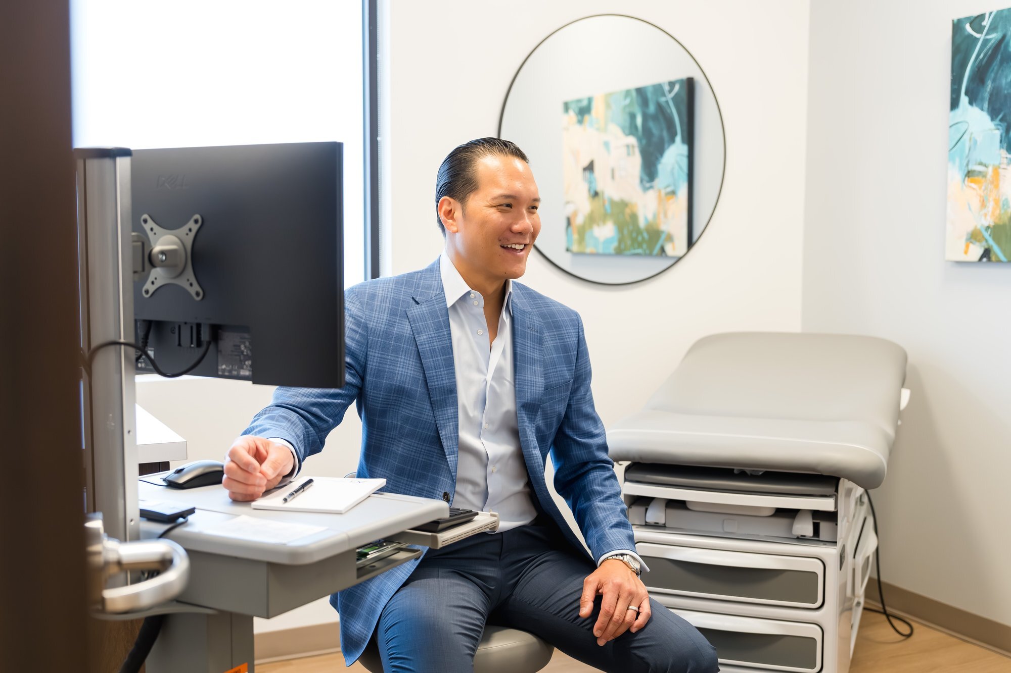 Austin Gastroenterology physician at desk in exam room