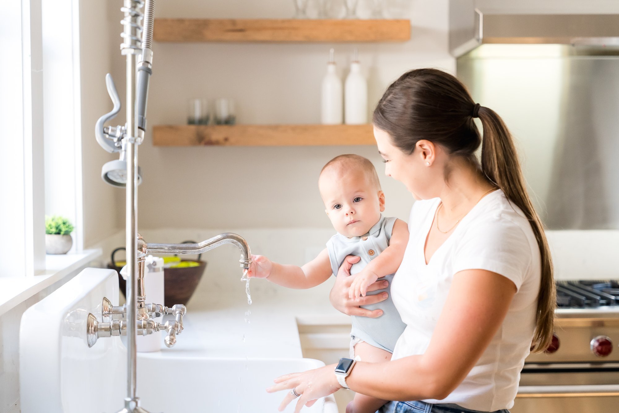 Nanny holding a baby at the kitchen sink, Austin