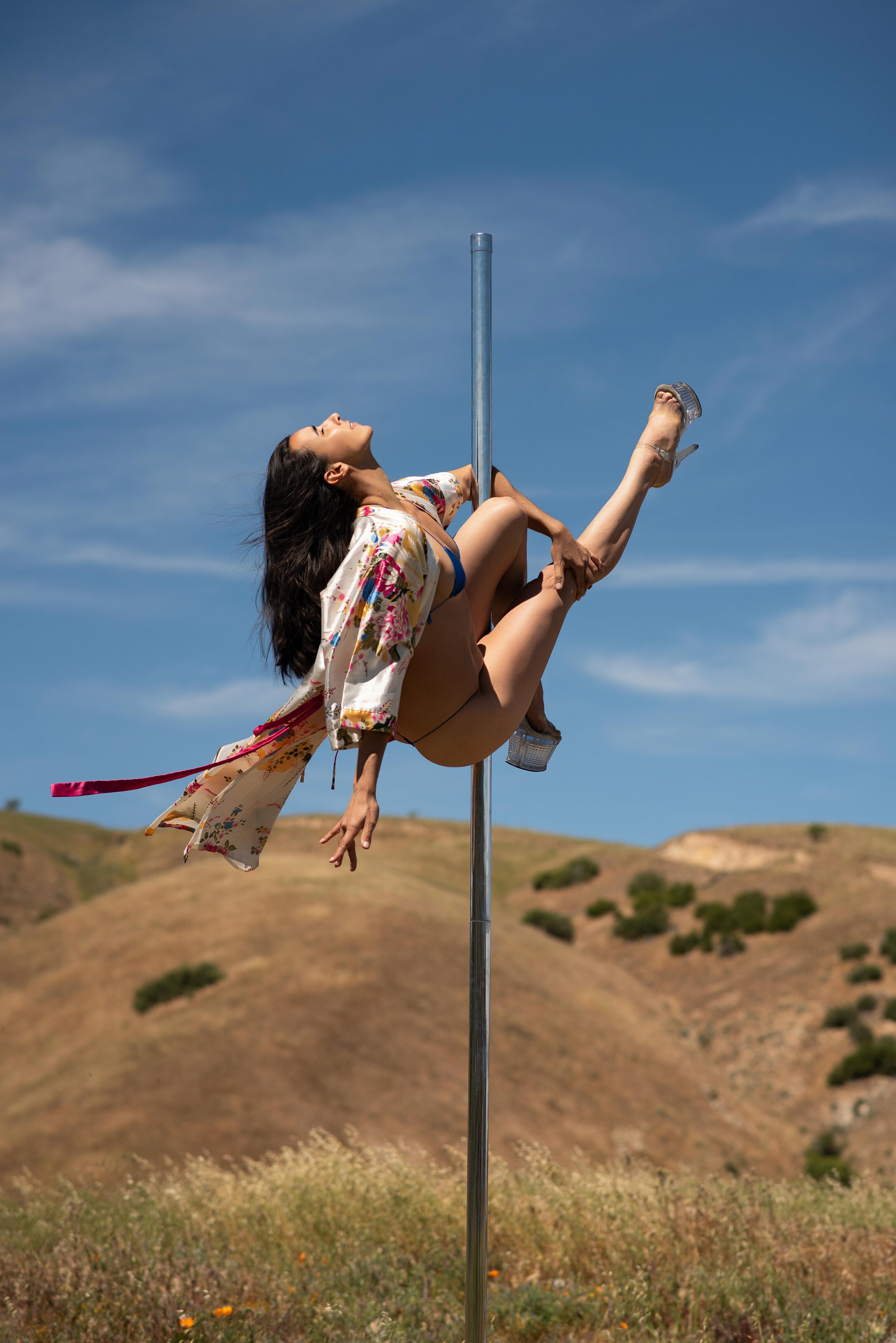 Pole dancer posing in a colorful wildflower field