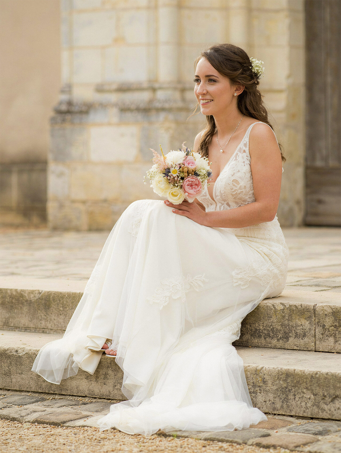 Bridal portrait on stone church steps in Normandy, France