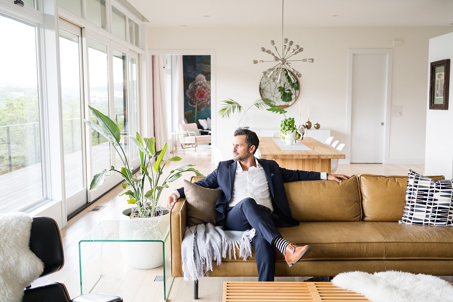 Architect relaxing on a couch in a bright, plant-filled living room