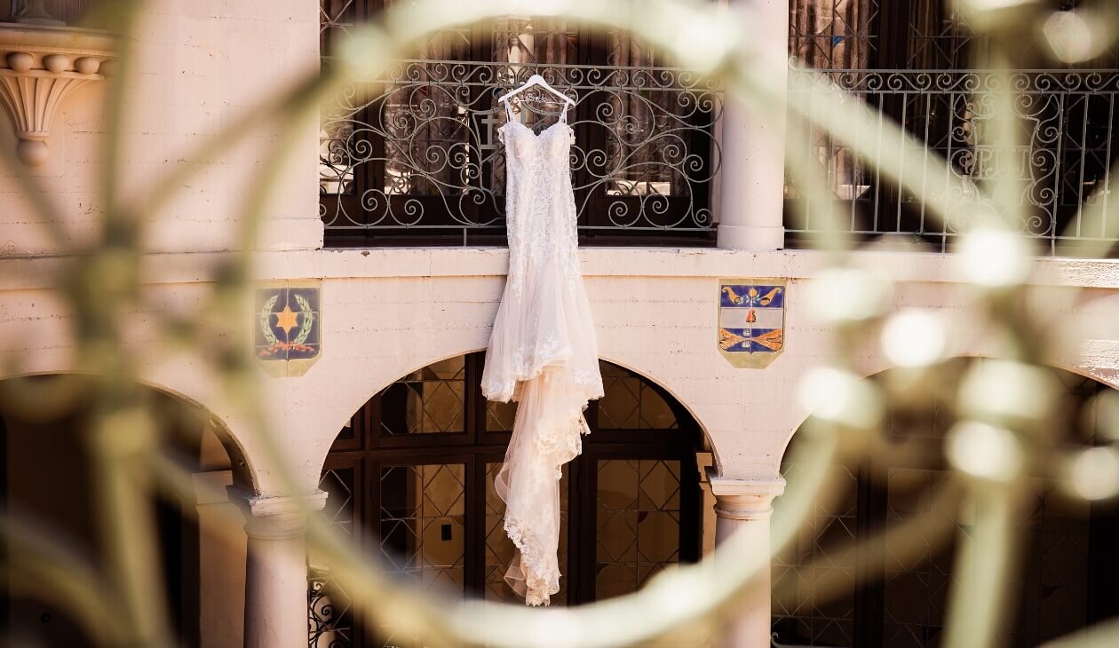Lace wedding dress hanging inside an ornate venue
