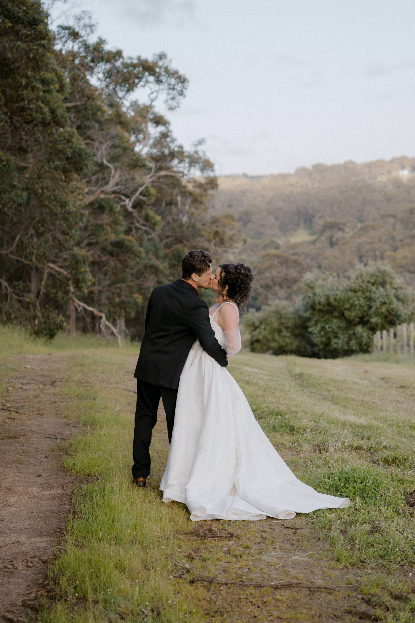 Dionne and Brett in the rolling hills with native trees and vineyards at Credaro Family Estate, Yallingup