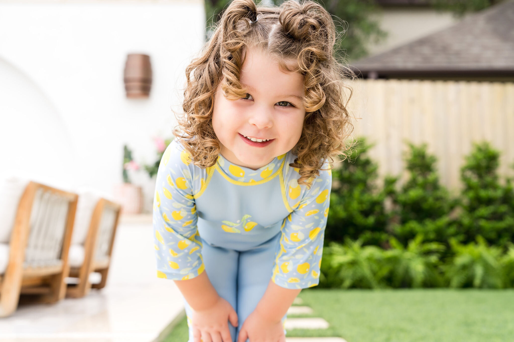 Girl wearing a lemon print rash guard for Splash About swimwear