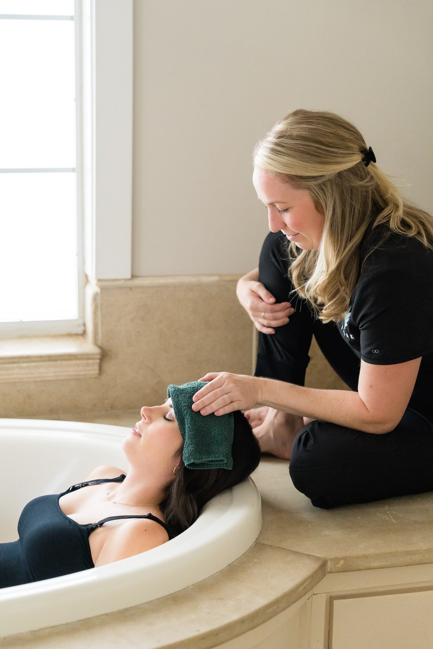 Postpartum doula providing bath care support for Stork Maternity Consulting