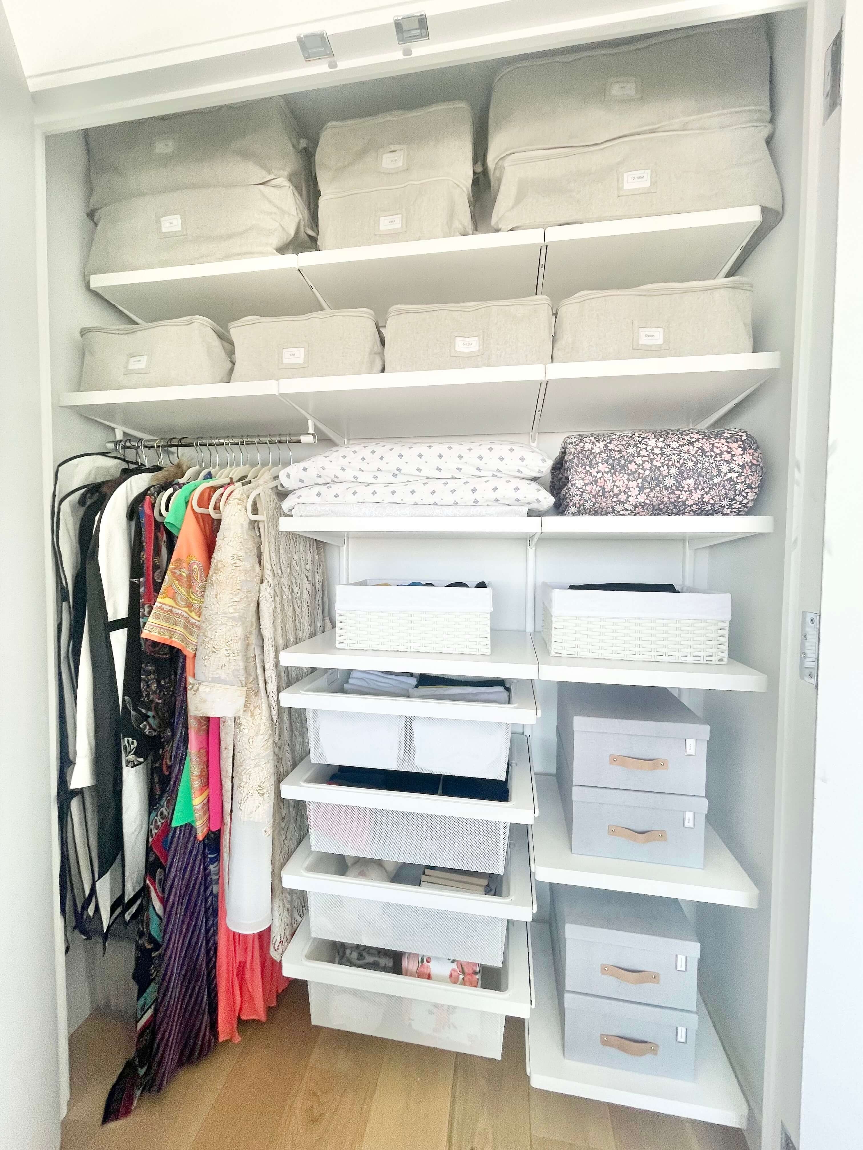 Organized bedroom closet with neatly folded bedding, labeled storage bins, and pull-out drawers.