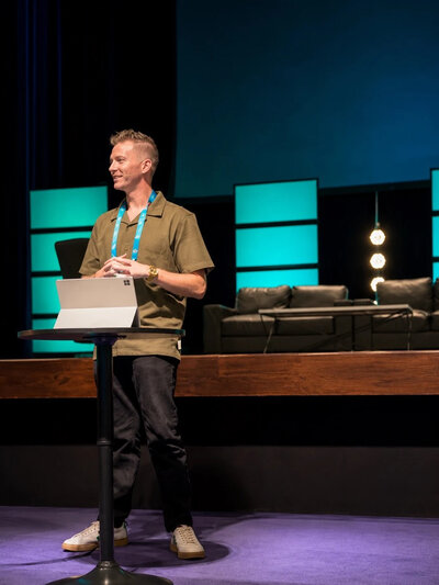 Kyle Vermeulen teaches from a church stage about disability, faith, and belonging.