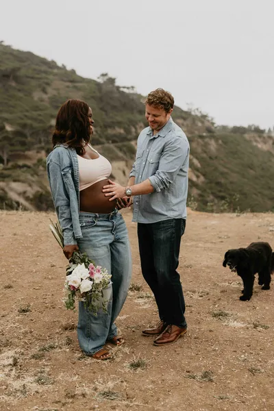 Family with a newborn and their dog on a coastal hillside trail in Los Angeles