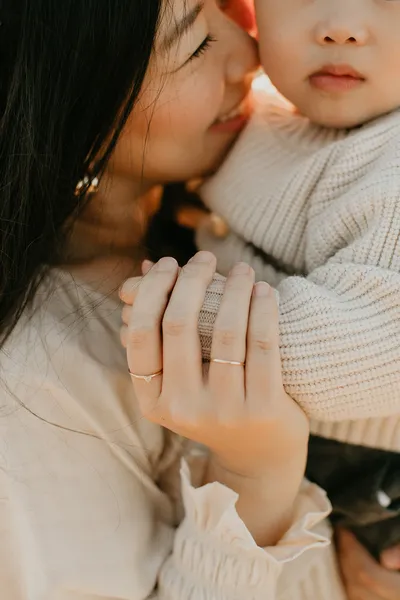 Mother touching noses with her newborn baby, tender in-home portrait