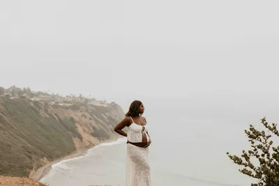 Expecting mother in white walking a foggy coastal path above the Pacific in Palos Verdes